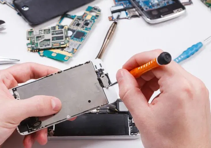 Repairman disassembling phone with screwdriver